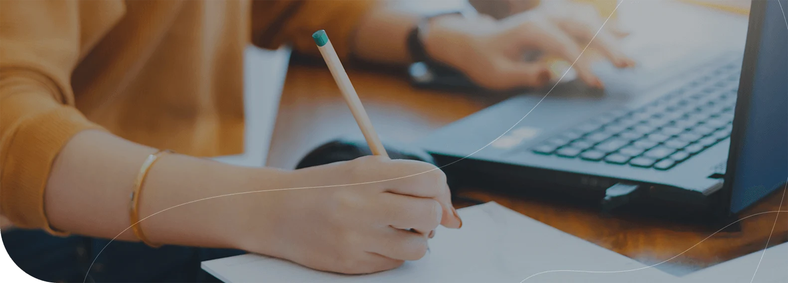 Joven escribiendo en un documento sobre su escritorio