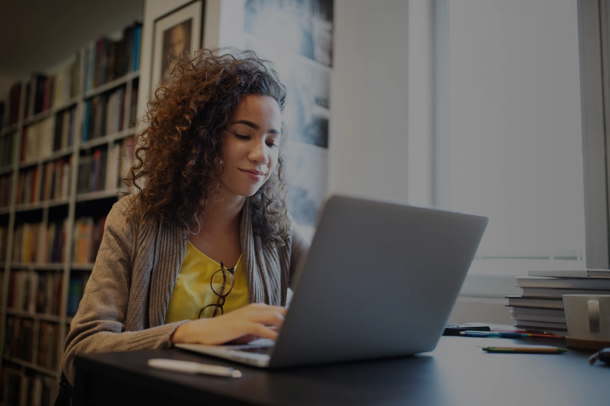 Mujer en una biblioteca con una laptop